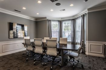 A conference room with a table and chairs and windows